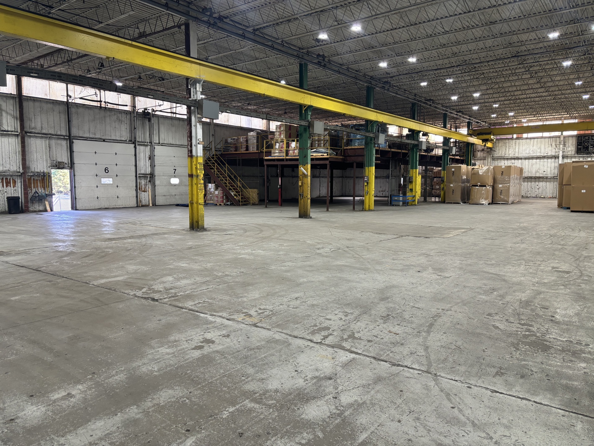 Inside the T2G Logistics cross-dock facility in Millville, NJ — open dock floor with overhead crane and dock doors 6 and 7